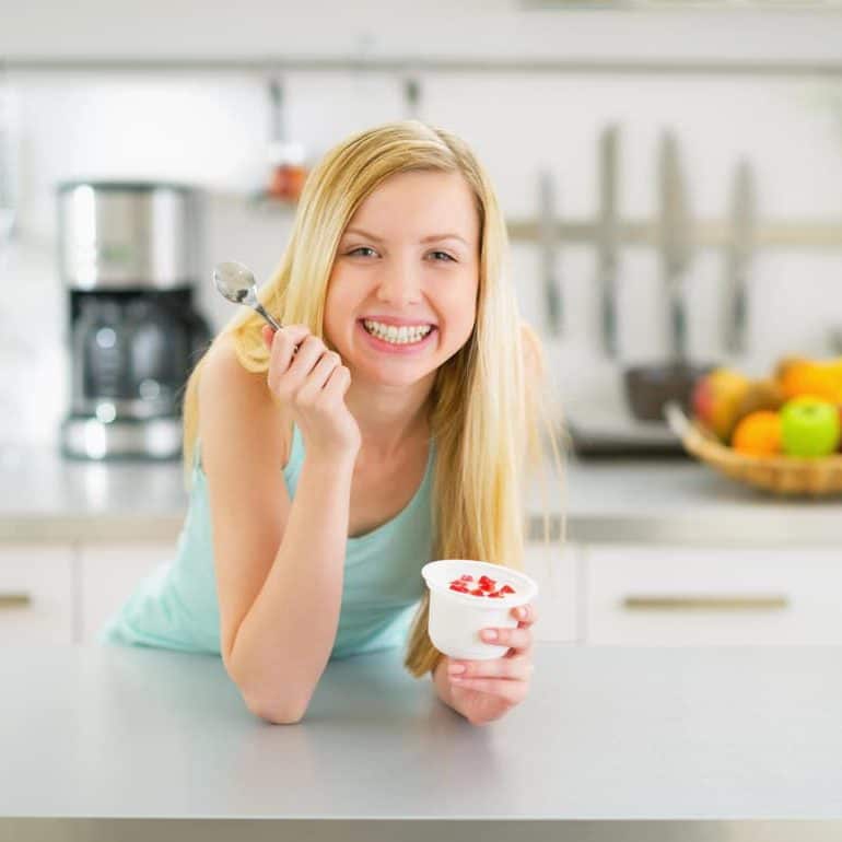 Femme qui mange un yaourt aux fruits